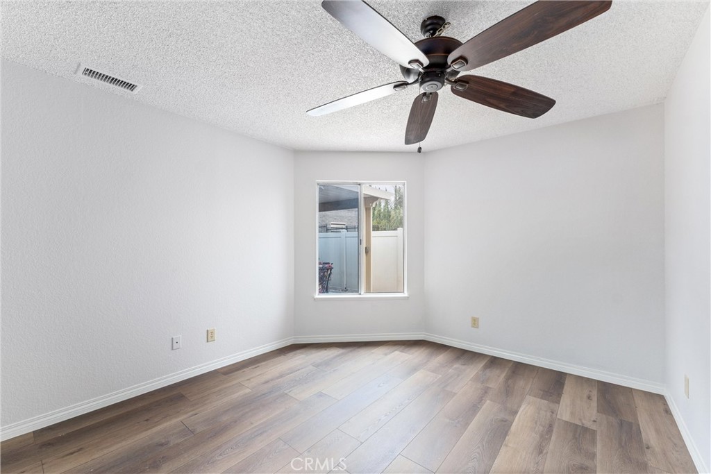 1159 Stone Pine Lane, Unit C Corona, CA 92879 - Photo 10 of 25 an empty room with a window and a fan
