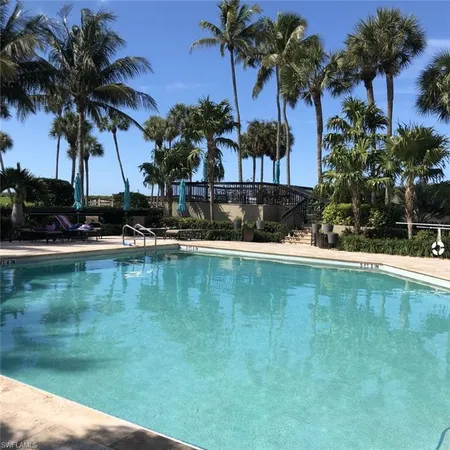 a view of swimming pool with table and chairs under an umbrella