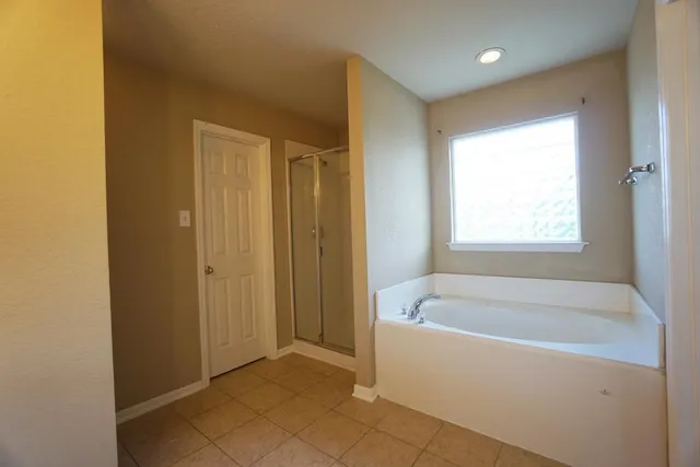 a white bath tub sitting in a bathroom next to a window