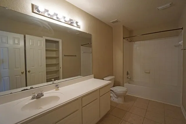 a bathroom with a double vanity sink toilet and a mirror