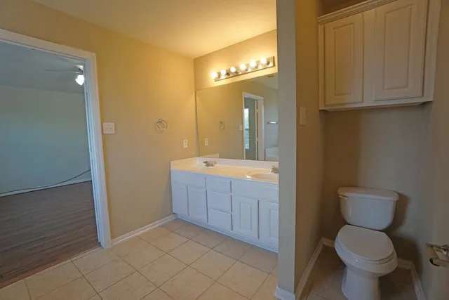 a bathroom with a granite countertop sink mirror vanity and toilet