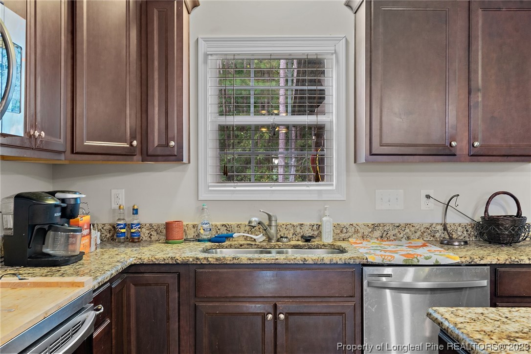 376 Tactical Drive Bunnlevel, NC 28323 - Photo 18 of 46 a kitchen with granite countertop a sink stove and cabinets