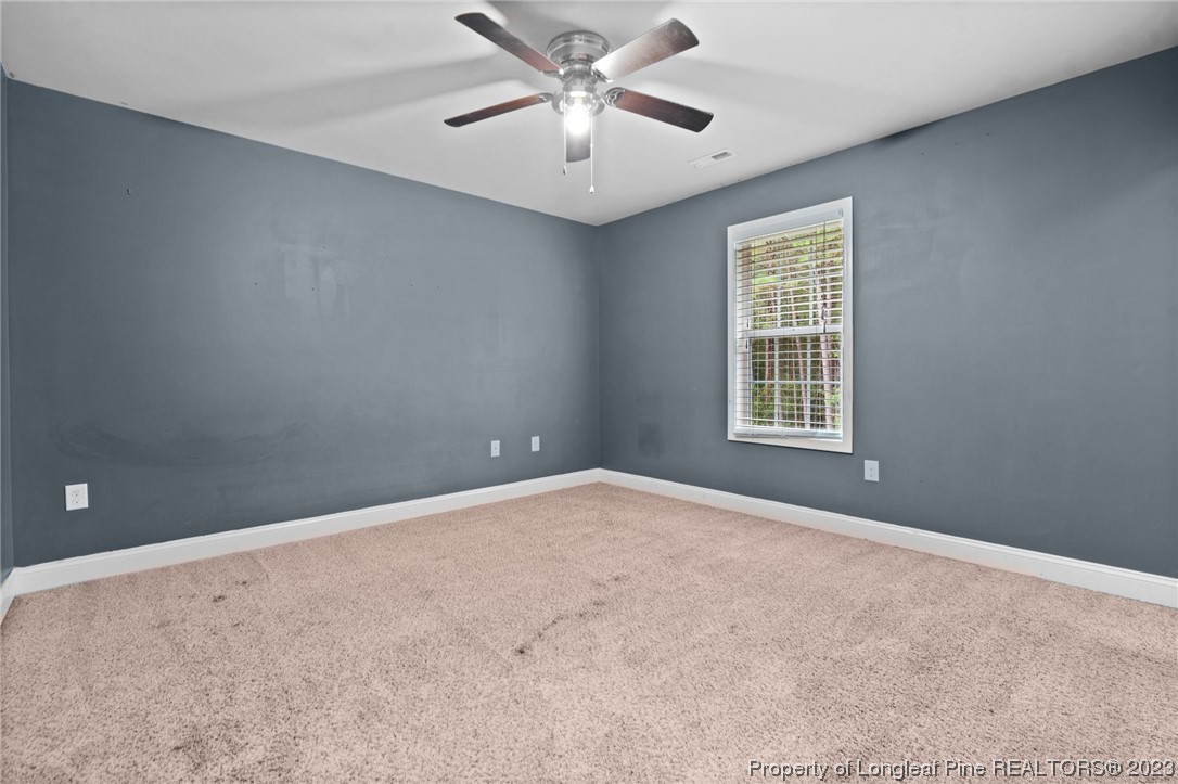 376 Tactical Drive Bunnlevel, NC 28323 - Photo 21 of 46 en empty room with windows and ceiling fan