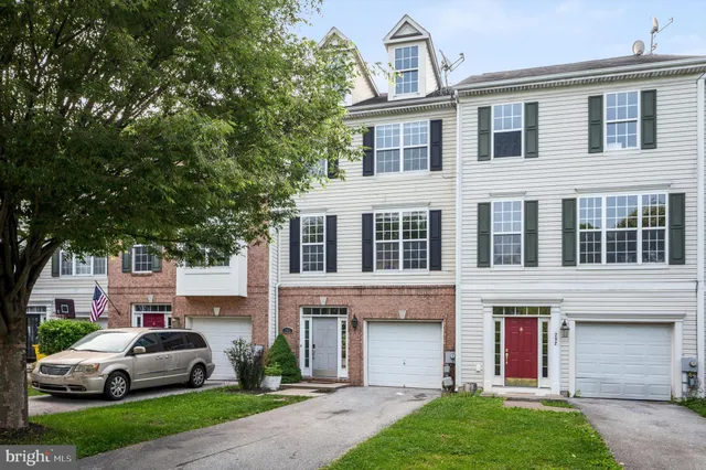 a front view of a house with a garden and parking