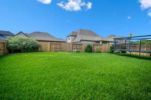 a view of a house with a big yard and large trees