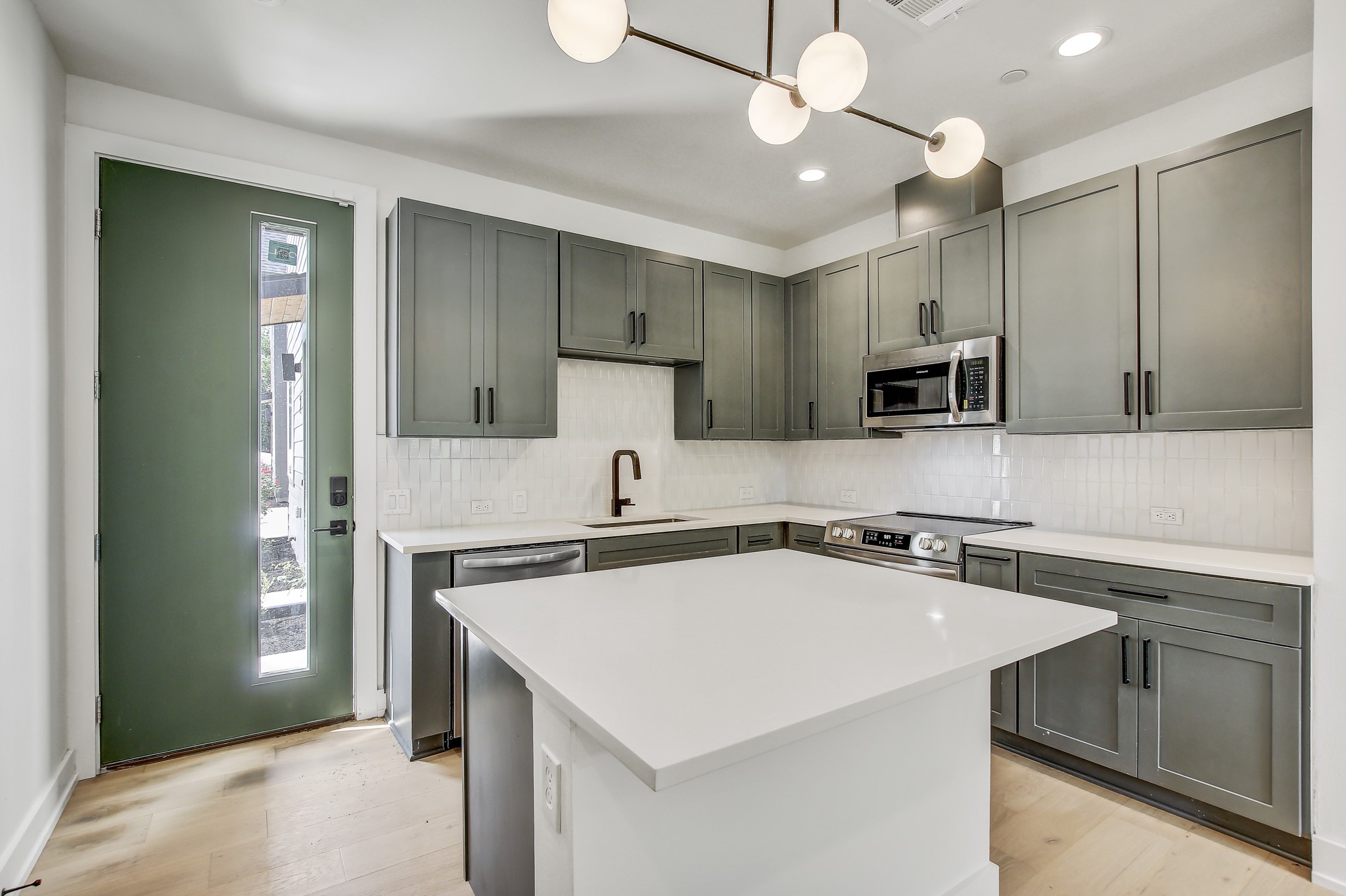 4127 East 12th Street, Unit 3 Austin, TX 78721 - Photo 2 of 29 Kitchen featuring stainless steel appliances, a sink, light countertops, backsplash, and recessed lighting