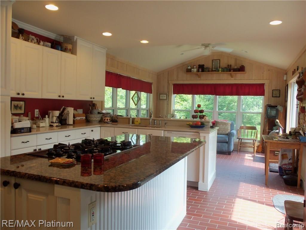 9906 Bergin Road Howell, MI 48843 - Photo 16 of 31 KITCHEN ISLAND AND GATHERING ROOM BEYOND