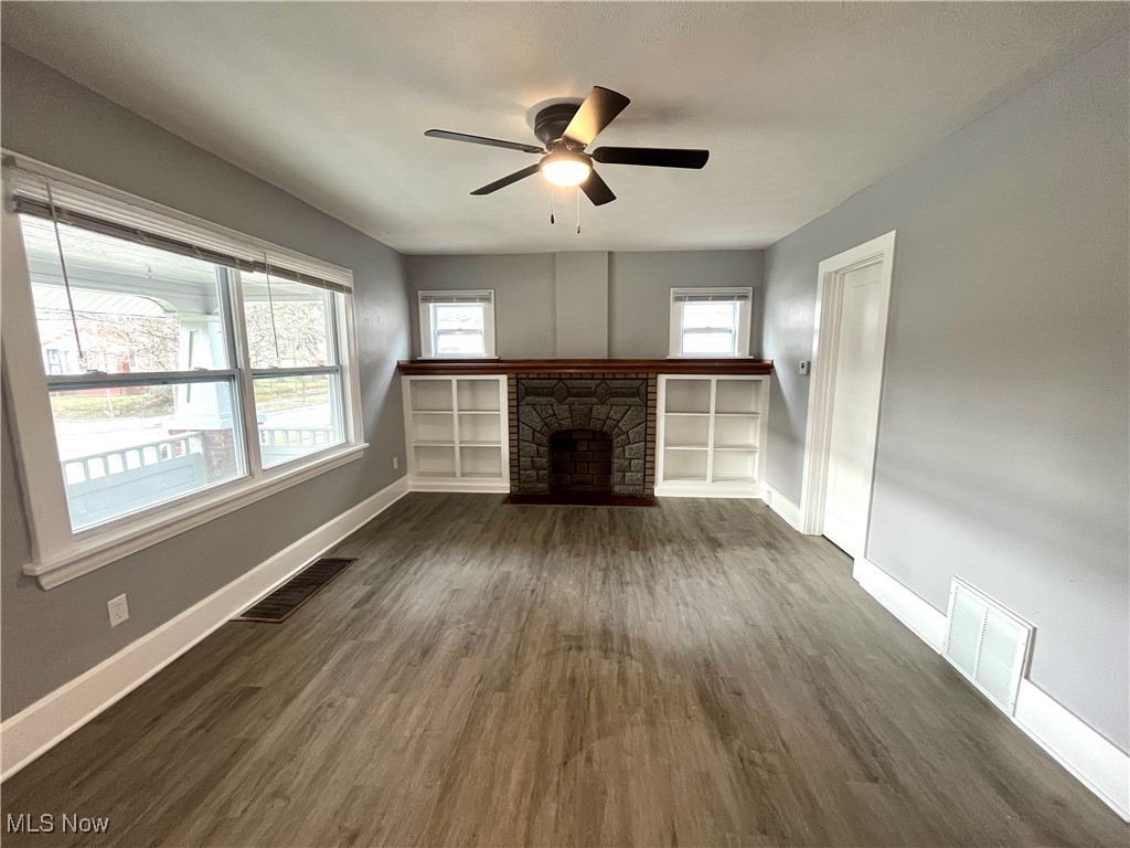 827 Inman Street Akron, OH 44306 - Photo 4 of 15 Unfurnished living room with dark wood finished floors, baseboards, and visible vents