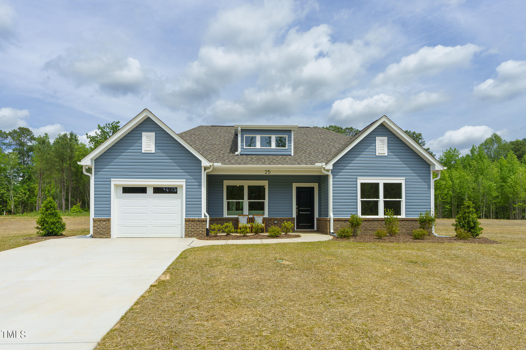 a front view of a house with yard and green space