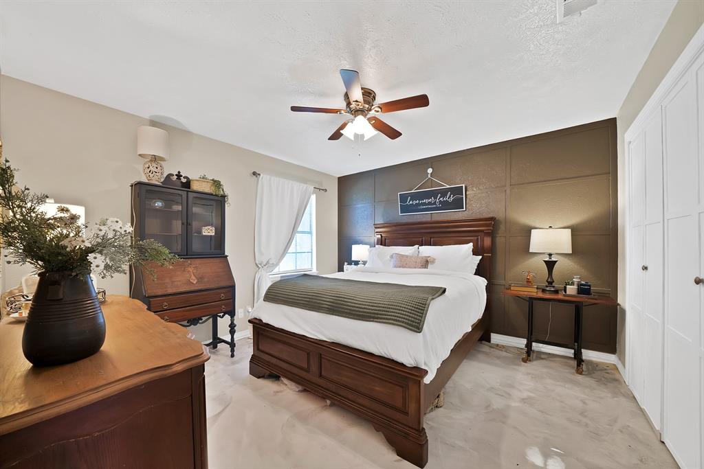 9519 County View Road Dallas, TX 75249 - Photo 17 of 31 Bedroom featuring a decorative accent wall, ceiling fan with integrated lighting, and carpeted flooring