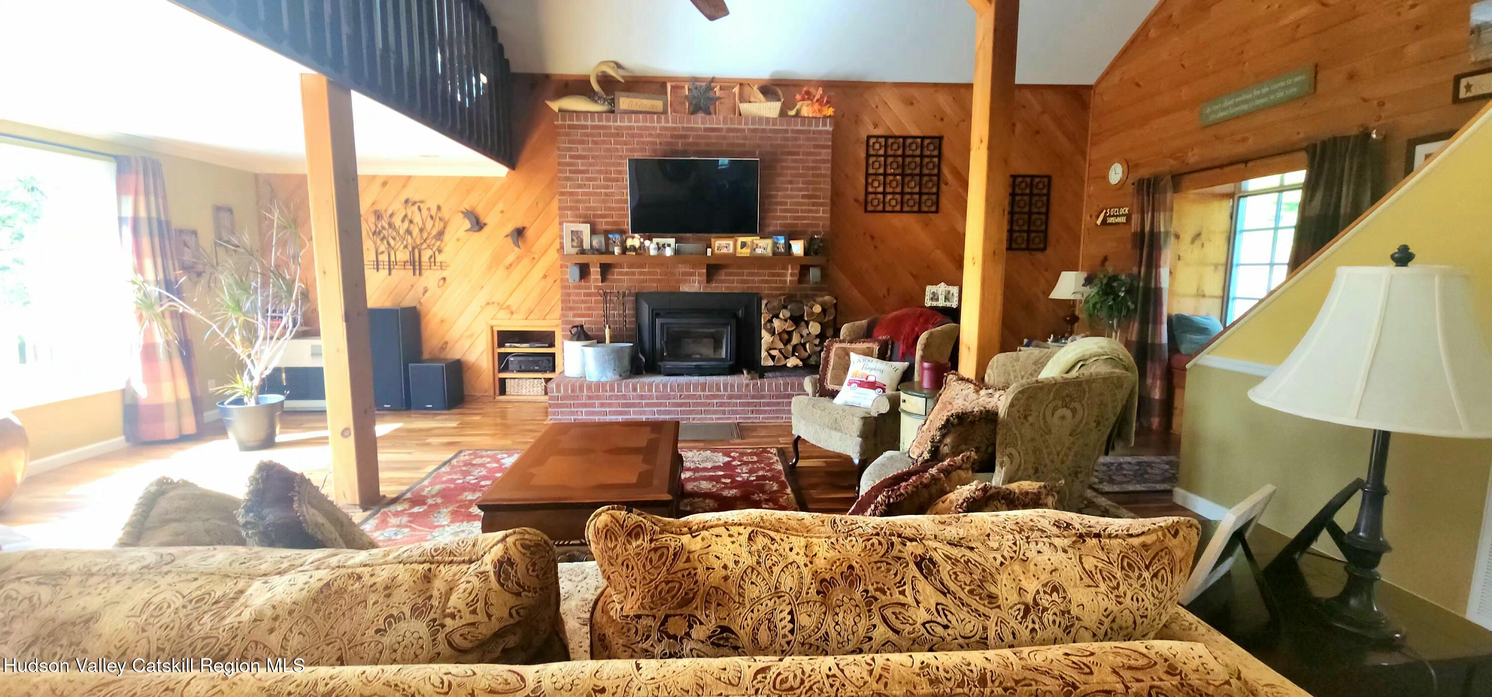 19 Pond View Road Ashland, NY 12468 - Photo 12 of 37 a living room with furniture a flat screen tv and a fireplace