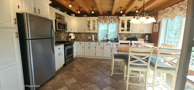 a kitchen with stainless steel appliances kitchen island granite countertop a refrigerator and a stove top oven