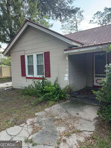 a backyard of a house with table and chairs
