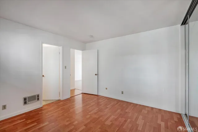 a view of an empty room with wooden floor