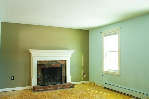 a view of a livingroom with a fireplace and a window