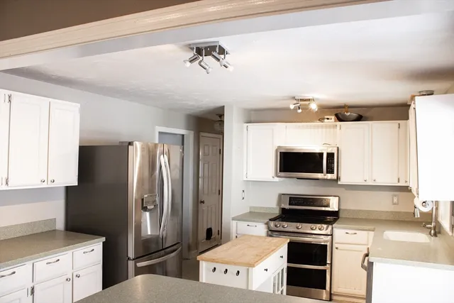 a kitchen with stainless steel appliances a refrigerator stove and microwave