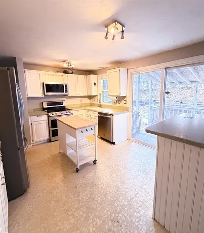 a kitchen with a stove a refrigerator and a microwave