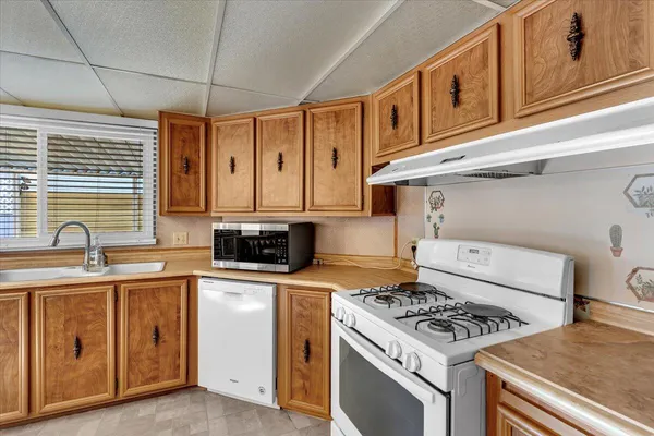 a kitchen with stainless steel appliances granite countertop a stove a sink and a microwave
