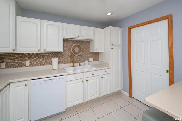 a kitchen with white cabinets and sink