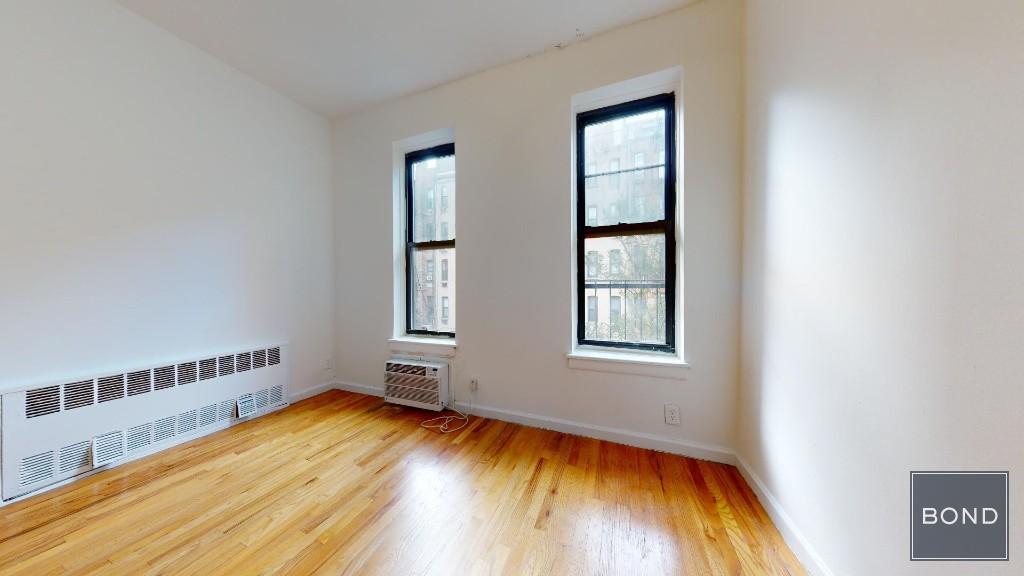 an empty room with a window and wooden floor