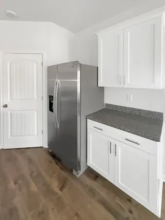 a large white kitchen with cabinets