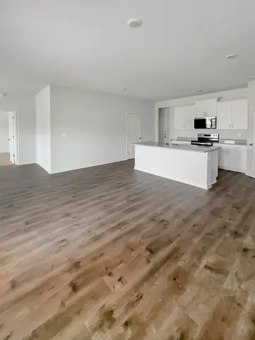 a kitchen with granite countertop white cabinets and refrigerator