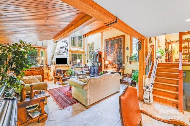 a living room with furniture a flat screen tv and floor to ceiling windows