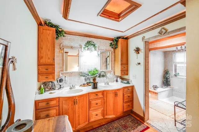 a spacious bathroom with a double vanity sink a mirror and a shower