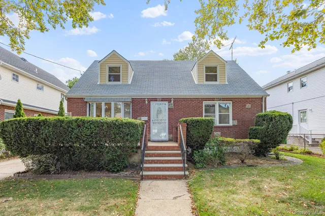 a front view of a house with garden and plants