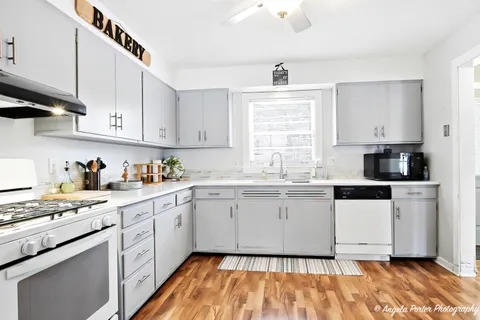 a kitchen with granite countertop white cabinets and white appliances