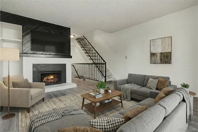 a living room with furniture a flat screen tv and a fireplace