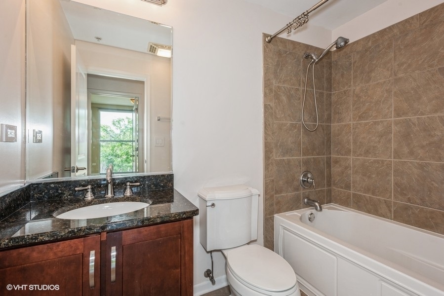 1228 Emerson Street, Unit 304 Evanston, IL 60201 - Photo 13 of 19 a bathroom with a granite countertop sink a mirror a bathtub and a toilet