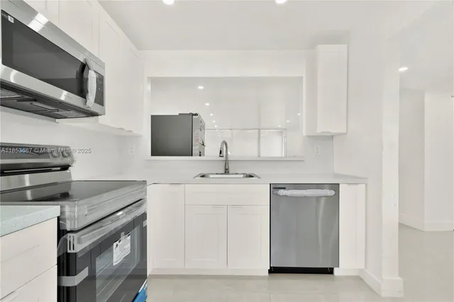 a kitchen with stainless steel appliances granite countertop a sink and a stove