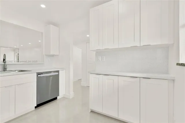 a kitchen with white cabinets and white appliances