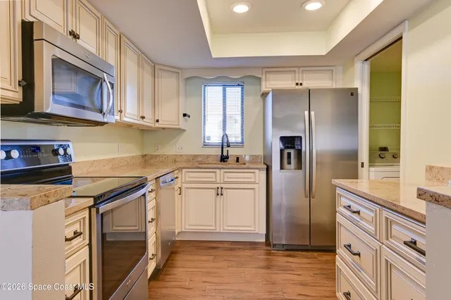 a kitchen with stainless steel appliances granite countertop a refrigerator sink and cabinets