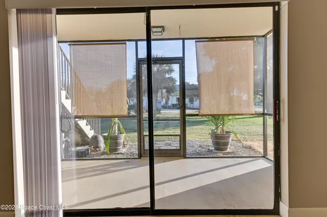 a view of a glass door with a yard from a window
