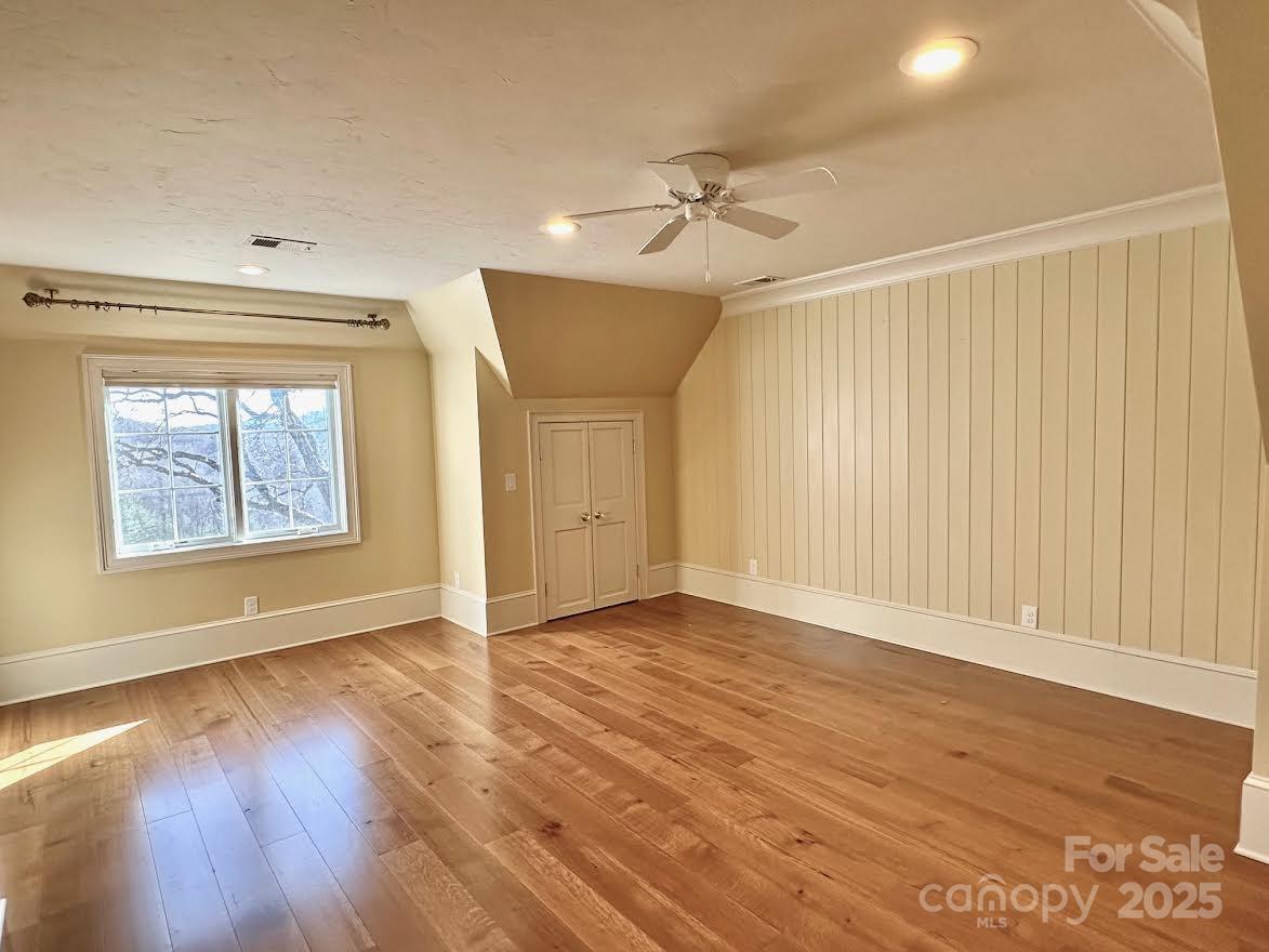 520 East Landing Ridge Circle Jefferson, NC 28640 - Photo 20 of 48 an empty room with wooden floor chandelier fan and windows