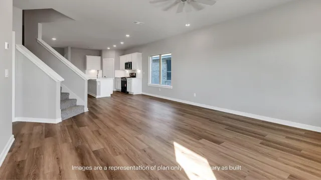 a view of a livingroom with wooden floor and stairs