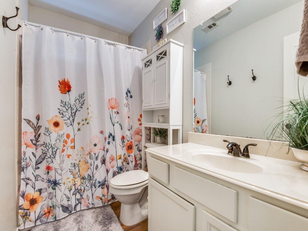 9962 Bell Rock Road Frisco, TX 75035 - Photo 23 of 28 a bathroom with a sink a toilet and shower curtain