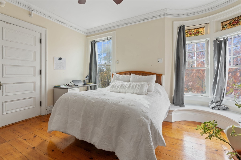 5 Claremont Street Worcester, MA 01610 - Photo 25 of 42 a bedroom with a bed and wooden floor