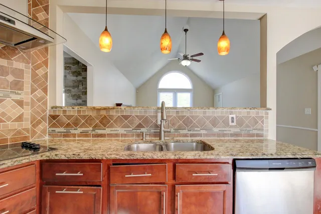 a kitchen with granite countertop a stove and a sink