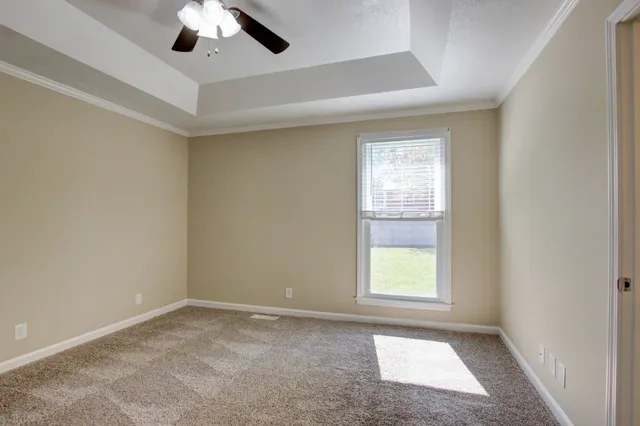 an empty room with a window and a ceiling fan