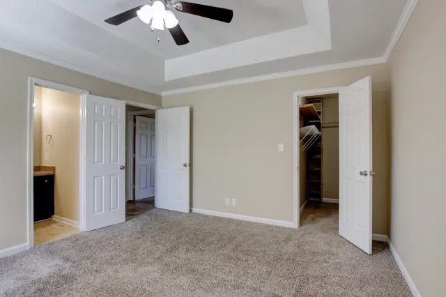 a view of an empty room with a chandelier fan