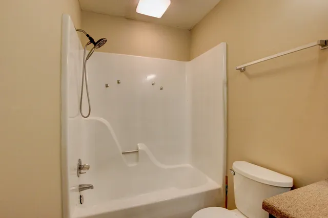 a bathroom with a granite countertop bathtub shower