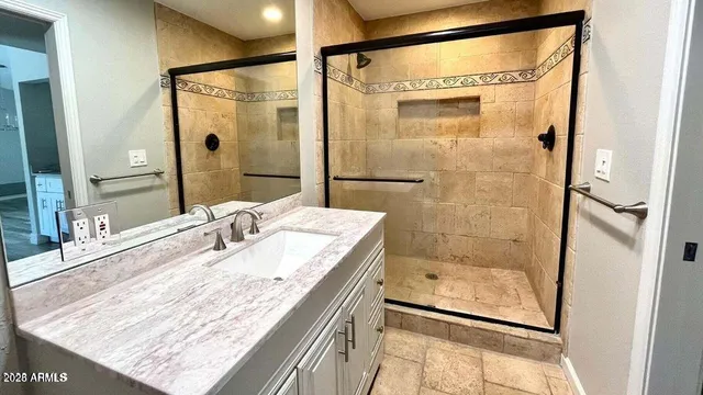 a bathroom with a granite countertop sink mirror and shower