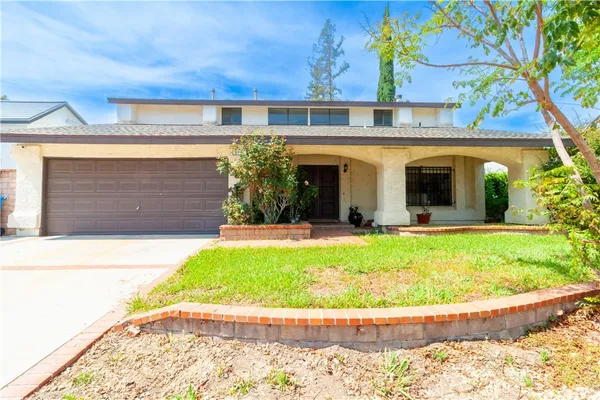 a view of a house with a garden and plants