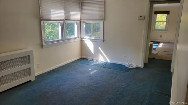 an empty room with a fireplace and windows