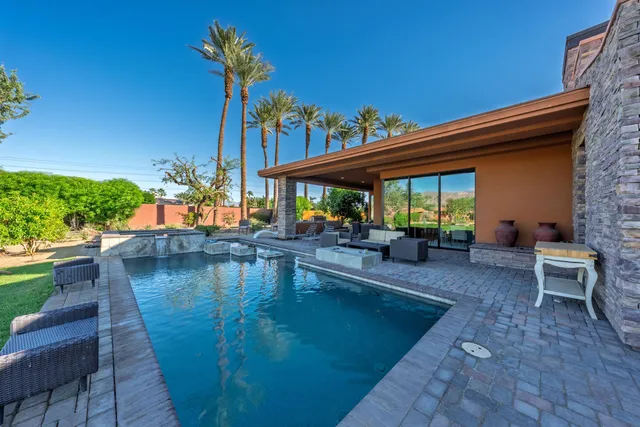 a view of a swimming pool with outdoor seating and plants
