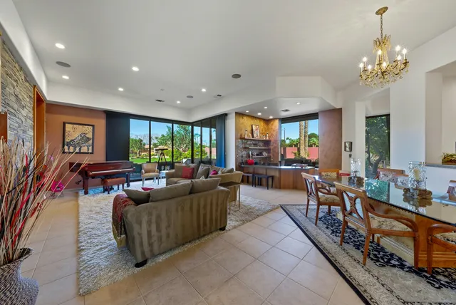 a living room with furniture a chandelier and a dining table