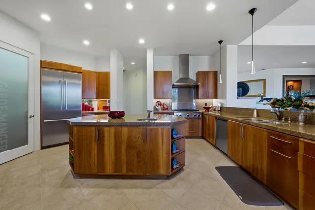 a kitchen with stainless steel appliances granite countertop a stove a sink a refrigerator and a refrigerator